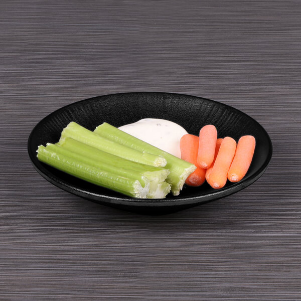 A plate of celery sticks and baby carrots on a black Elite Global Solutions Hermosa melamine plate.