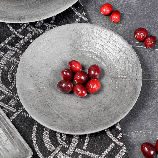 A set of Elite Global Solutions cement embossed coupe melamine plates with cranberries on them.