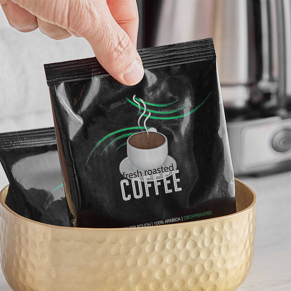 A hand holding a bowl with a packet of Decaf Room Service coffee.