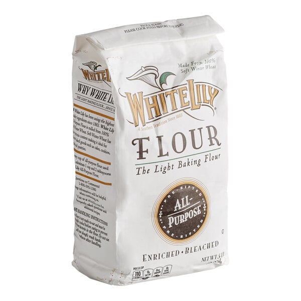 A white paper bag labeled 'White Lily Flour All-Purpose' with gold and brown accents, standing upright.