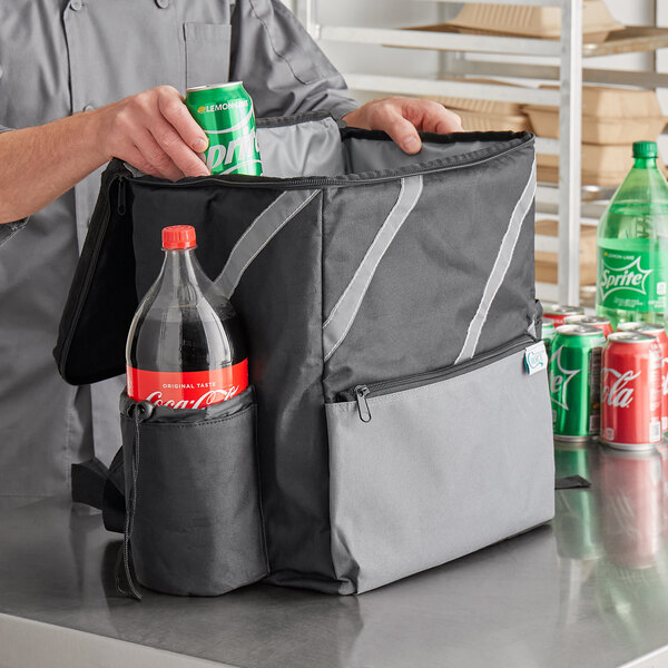 A man in a chef's uniform putting a green soda can in a Choice black insulated cooler backpack.