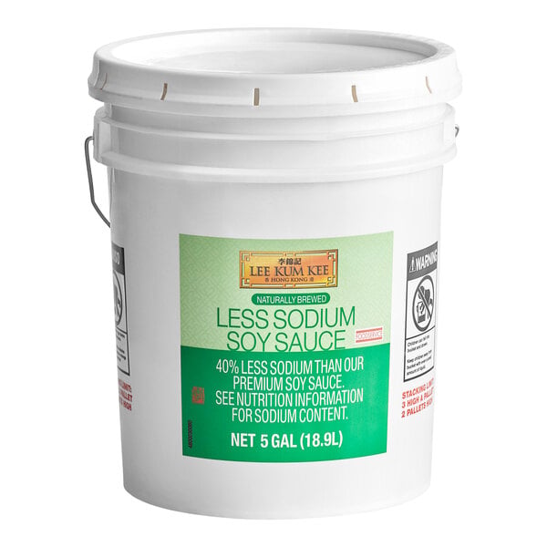A large white plastic bucket with a green label indicating it contains 5 gallons (18.9L) of Lee Kum Kee Less Sodium Soy Sauce.
