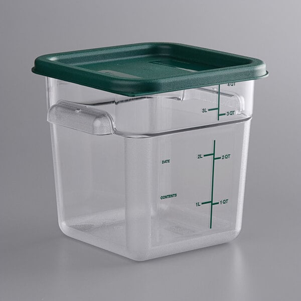 A clear square Vigor polycarbonate food storage container with a green lid.