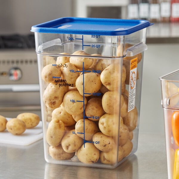 A Vigor clear square food storage container on a counter filled with potatoes.