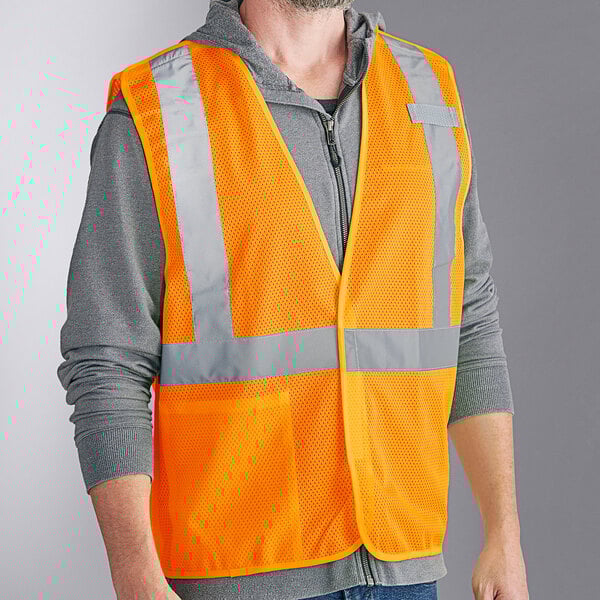 A man wearing an orange Ergodyne high visibility mesh vest with reflective stripes.