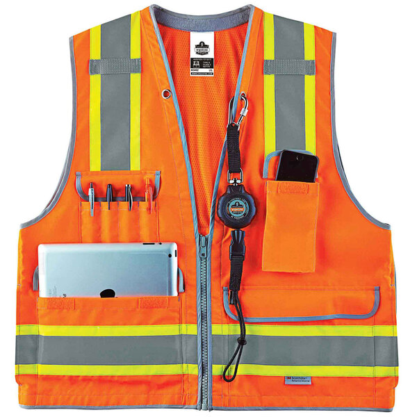 An orange Ergodyne heavy-duty surveyor vest with yellow reflective stripes and multiple pockets, including a cell phone and a pen.