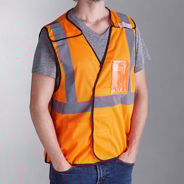 A person wearing an orange Ergodyne high visibility mesh vest.