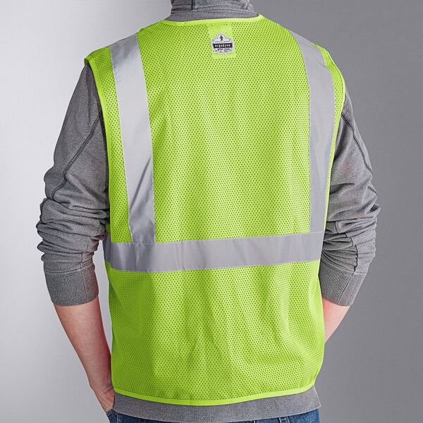 A person wearing an Ergodyne lime green reflective mesh safety vest.