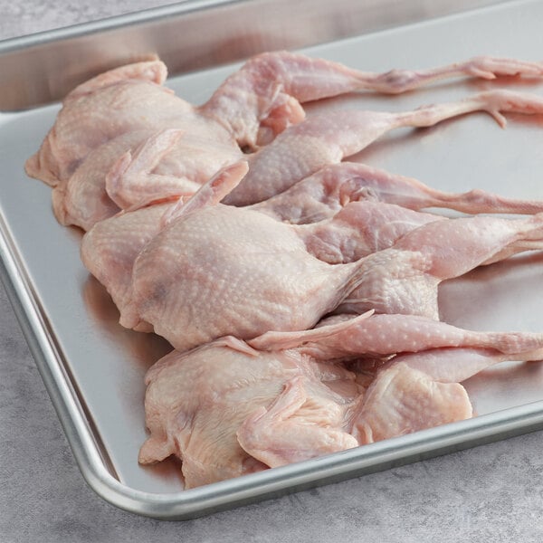 A tray of raw semi boneless quail with feet.