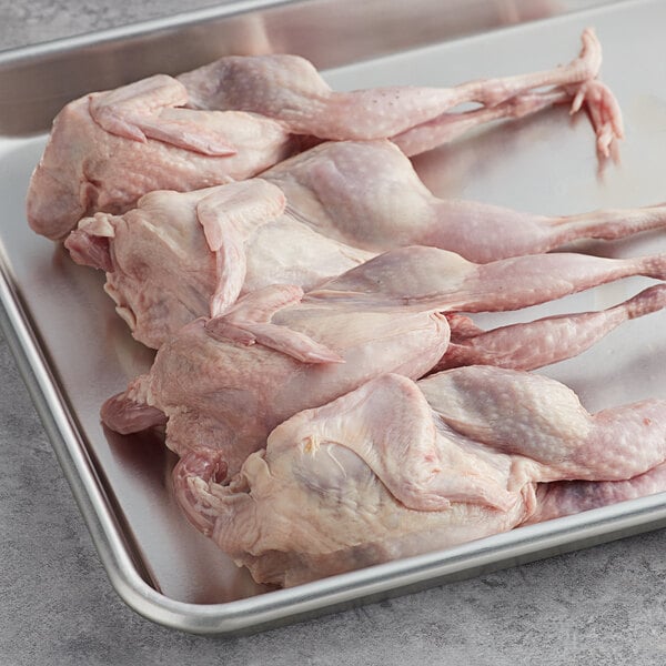 A tray of raw Manchester Farms quail with feet.