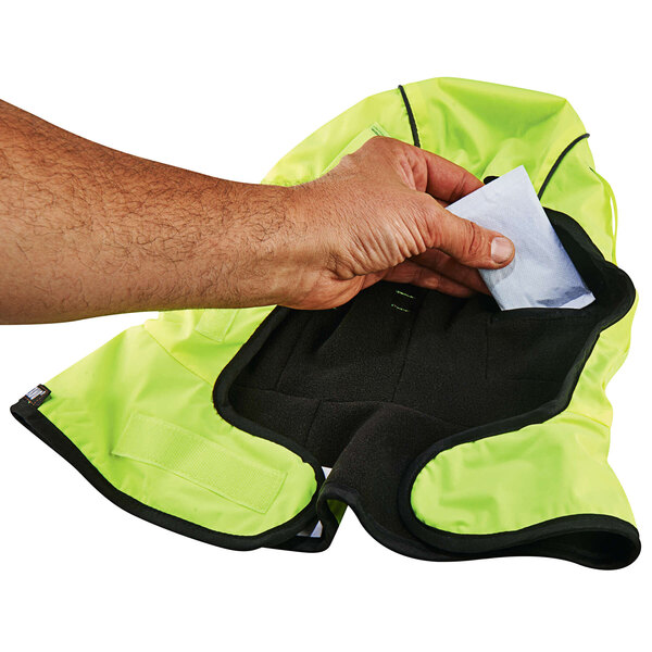A hand putting a piece of paper in an Ergodyne N-Ferno hand warming pack.
