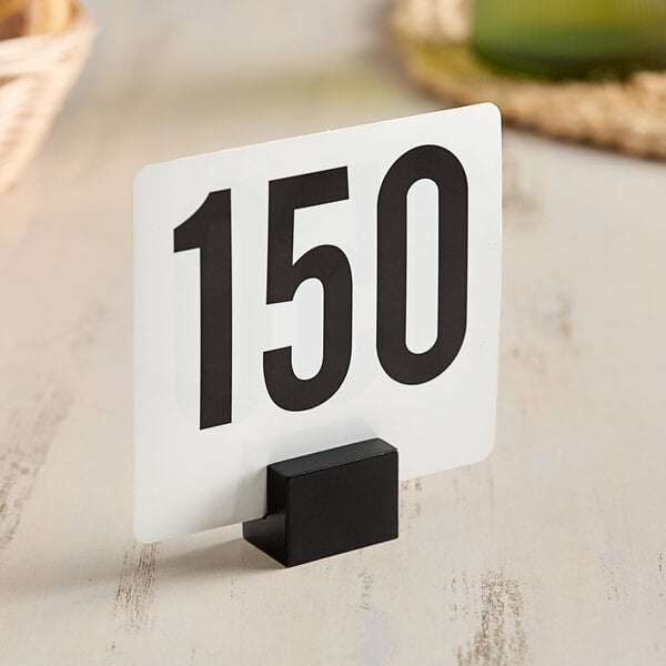 An American Metalcraft black rectangular hammered table card holder with a white sign and black numbers.