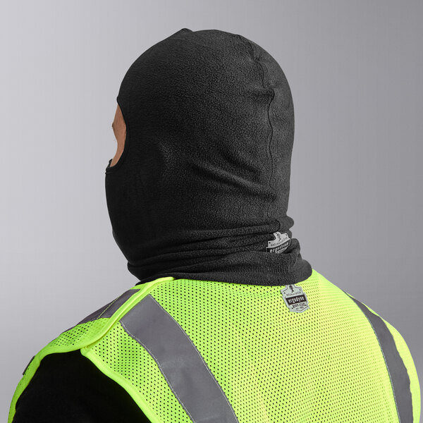 A man wearing an Ergodyne black fleece balaclava and a yellow safety vest.
