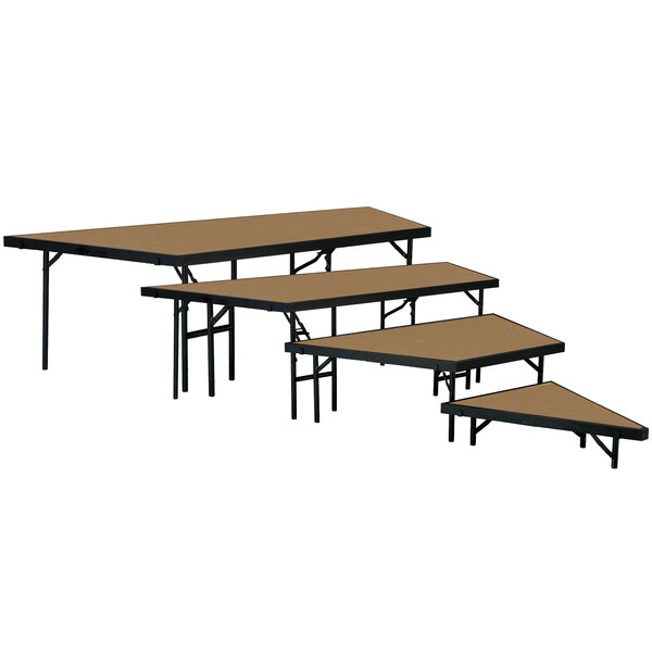 A set of National Public Seating stage pie tables with hardboard surfaces on a stage.