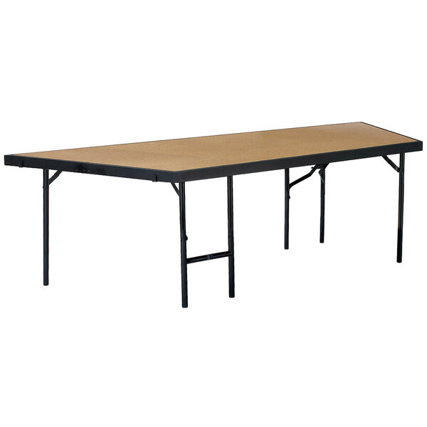 A rectangular table with black legs and a hardboard surface on a National Public Seating portable stage pie unit.