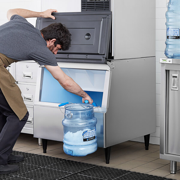 A man using a Hoshizaki ice storage bin to fill a water bottle.