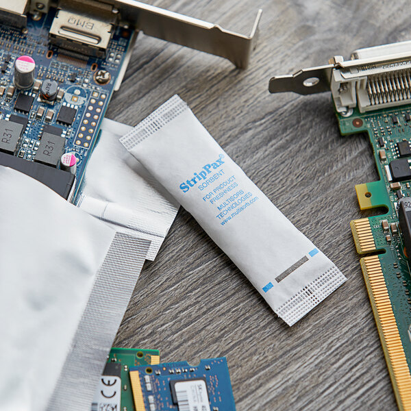 A close-up of a computer circuit board with a Multisorb white packet with blue text on it.