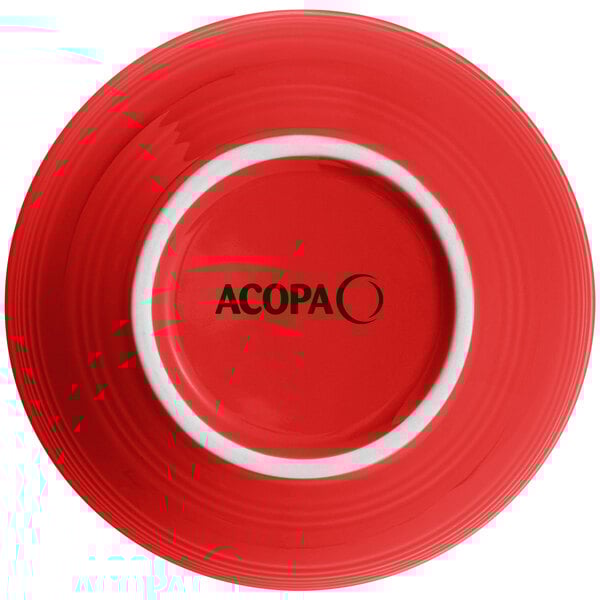 A red stoneware bowl with a black circle on it and the word Acopa in black.