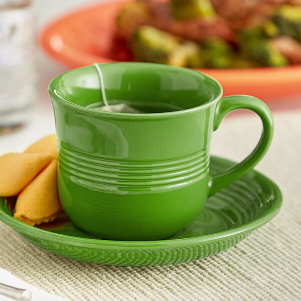 An Acopa Capri Palm Green stoneware cup with a tea bag on a plate.