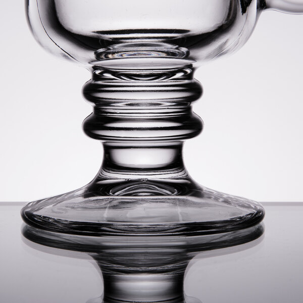 A close up of a Libbey clear glass Irish coffee mug with a white background.