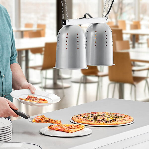 silver hanging heat lamp over pizzas on counter