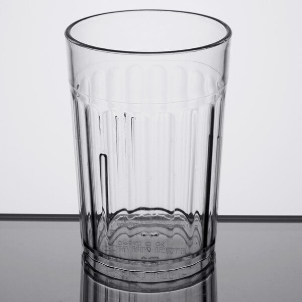 A Carlisle clear plastic tumbler on a white table.