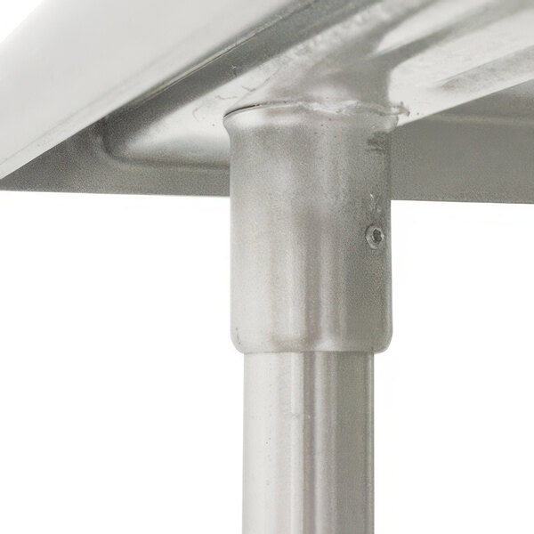 A close-up of the metal base of an Advance Tabco stainless steel work table.