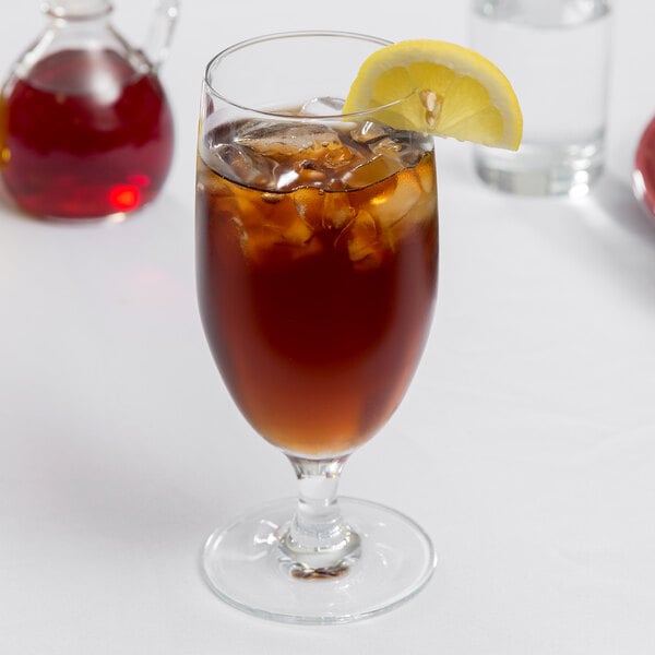 A Stolzle Nadine goblet of iced tea with a lemon slice on top.