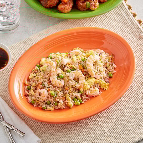 Acopa Valencia Orange stoneware coupe platter with shrimp fried rice and broccoli on a table.