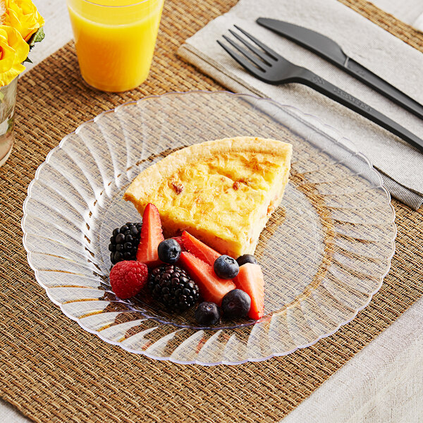 A WNA Comet clear plastic plate with a slice of pie and a fork on a table.