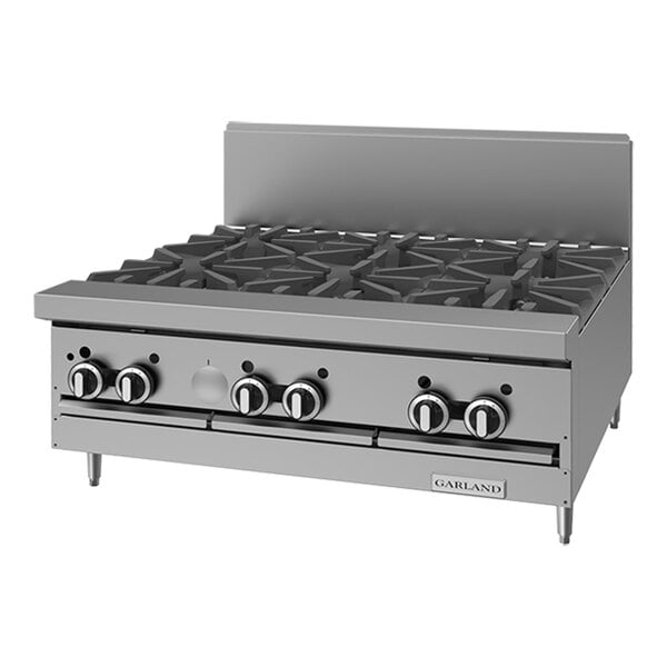 A stainless steel commercial 6-burner natural gas range top with control knobs and a backsplash.