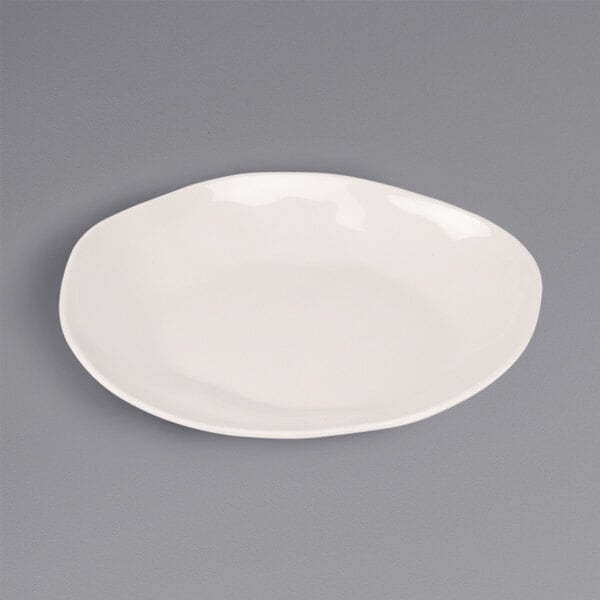 A Cal-Mil ivory melamine plate on a gray surface.