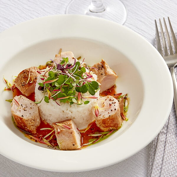 A white plate with rice and a piece of Big Pop's Whole Alligator meat with a sprig of herbs.