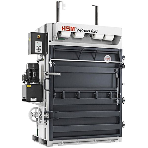 A close-up of a large HSM V-Press 820 Plus baler with white labels and a white door.