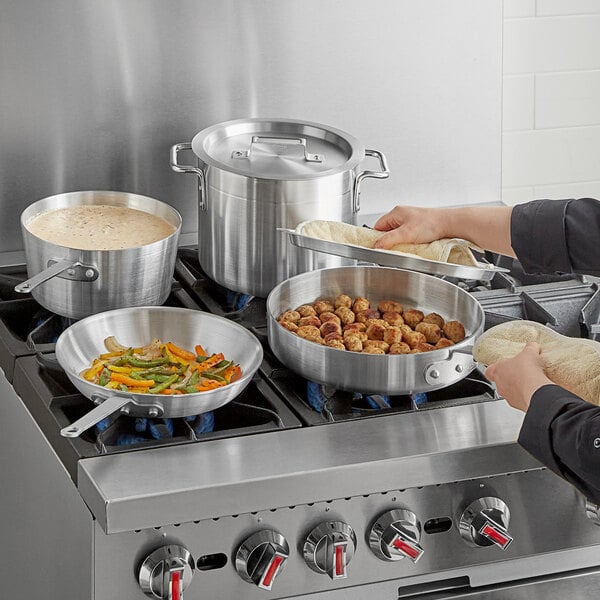 A woman cooking food in a Choice aluminum pan.