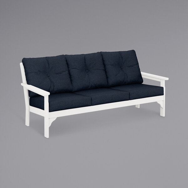 A white POLYWOOD Vineyard sofa with navy cushions.