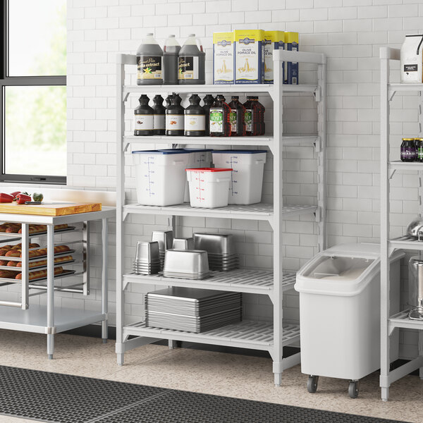 A white Cambro Premium Camshelving unit with 5 vented shelves holding food containers.