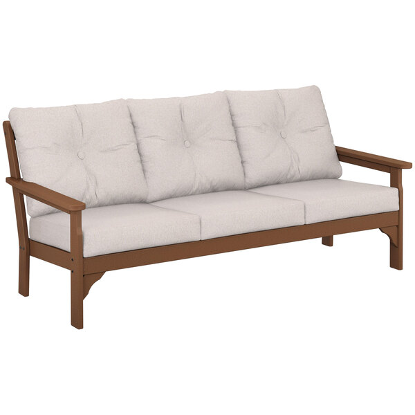 A POLYWOOD teak sofa with white cushions.