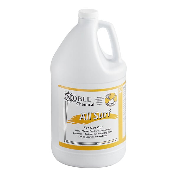 A white jug of Noble Chemical All Surf All Purpose cleaner with a yellow label on a table.