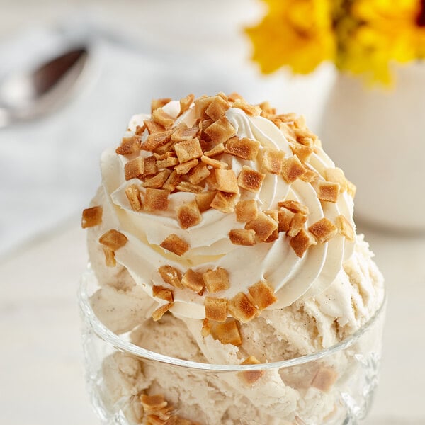 A bowl of ice cream with JOY waffle cone crumbles and whipped cream.