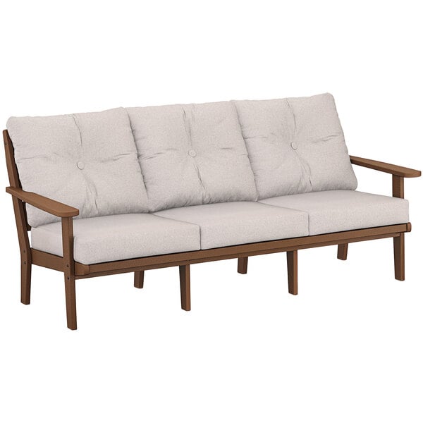 A POLYWOOD outdoor sofa with white cushions on it.