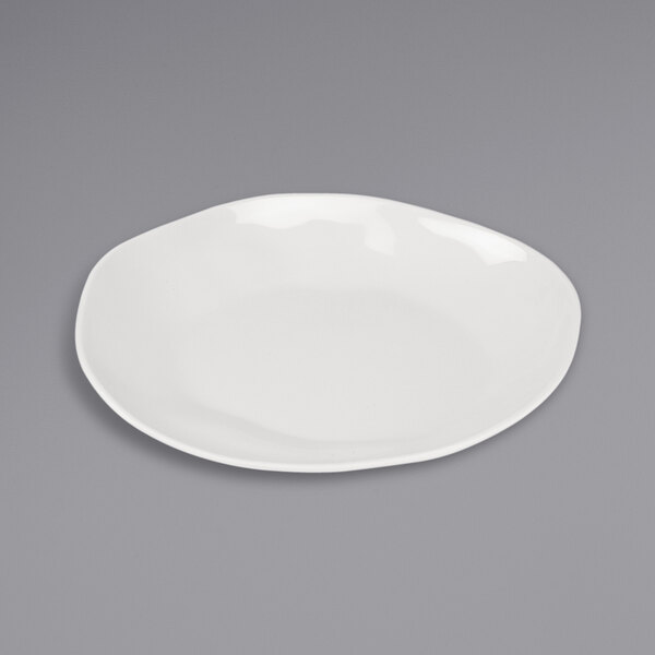 A Cal-Mil ivory melamine plate on a gray surface.