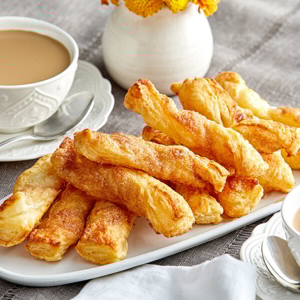 A plate of cinnamon sugar pastries with a cup of tea.