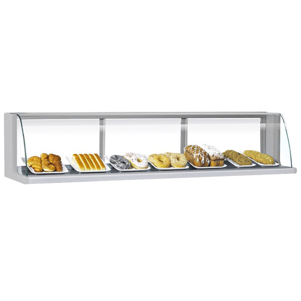 A Turbo Air stainless steel low profile top dry display case filled with different types of pastries on a bakery counter.