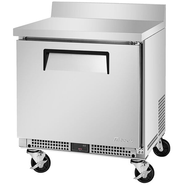 A silver Turbo Air worktop refrigerator with wheels.