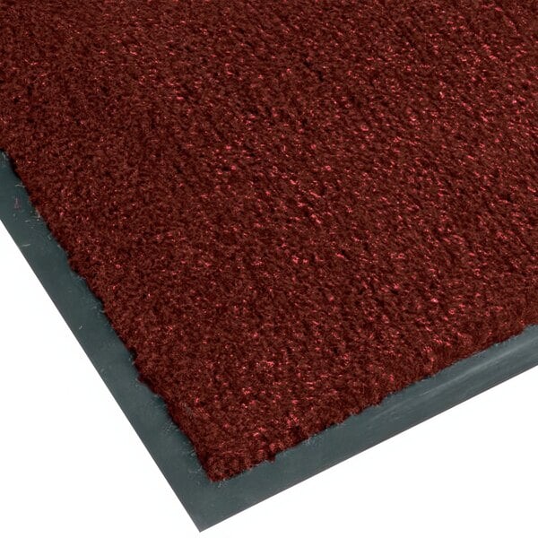 A crimson Notrax carpet entrance mat with a grey border.