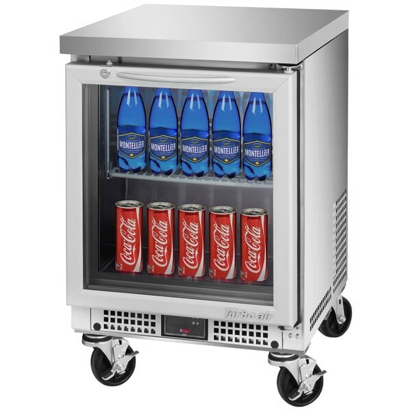 A Turbo Air stainless steel undercounter refrigerator with bottles and cans inside.