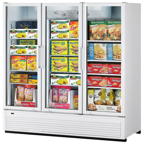 A Turbo Air Super Deluxe white freezer full of food on shelves.