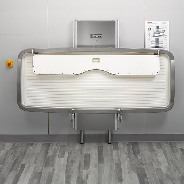 A white Koala Kare changing station with a metal frame.