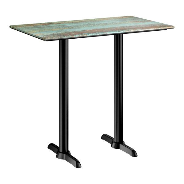 A rectangular bar height table with a textured canyon painted faux metal finish top and black end base plates.
